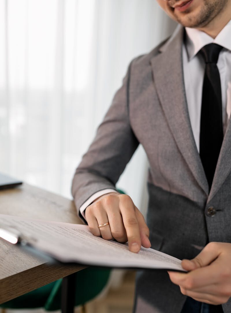 Business professional in suit reviewing important documents at the office.