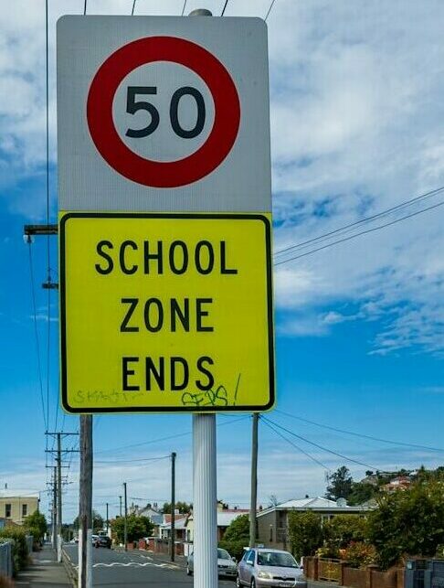 a yellow and white sign that says school zone ends