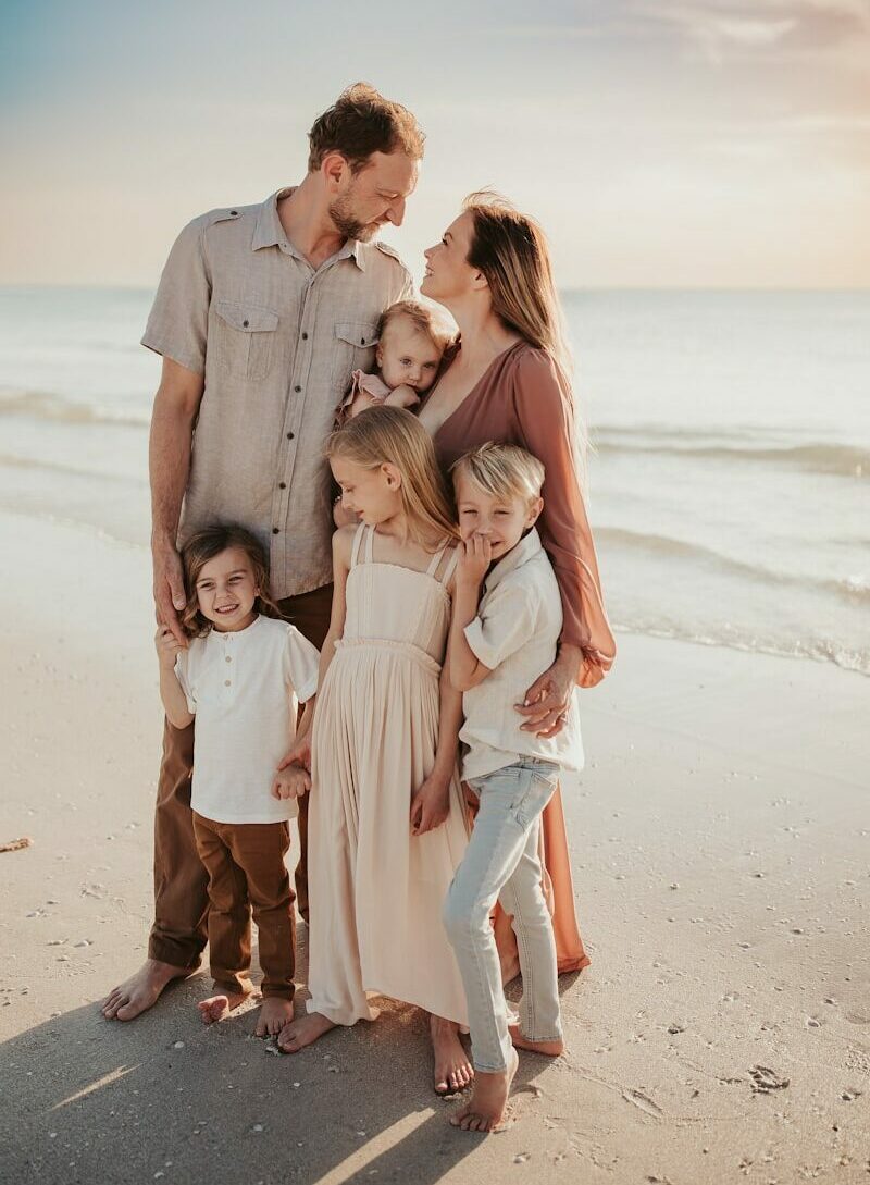 a family posing on a beach