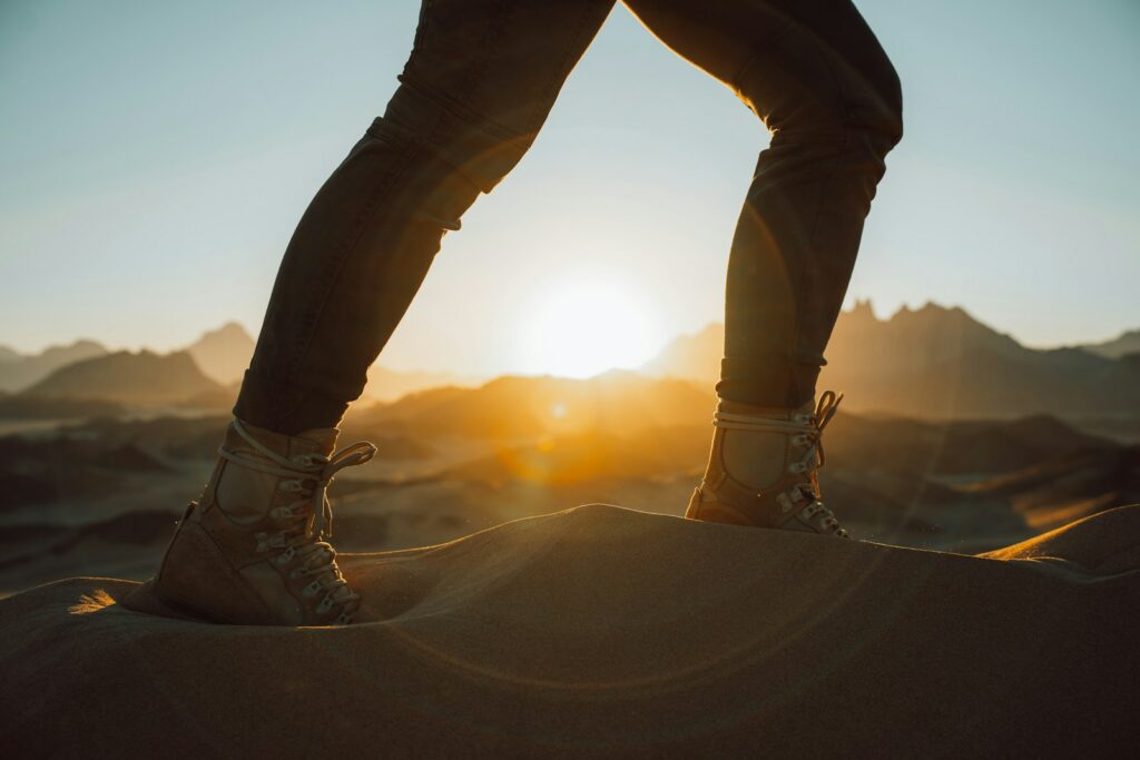 a person standing on top of a sand dune